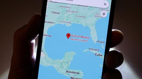 A person holds a mobile phone which shows the Gulf of Mexico, as bordered by the US, Mexico and Cuba, on Google Maps.