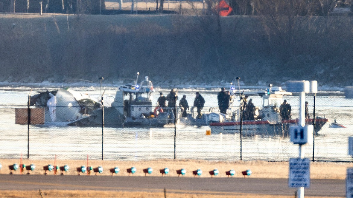 Rescue teams search the wreckage of the plane that collided with a military helicopter in Washington DC. They are on boats in the Potomac River.