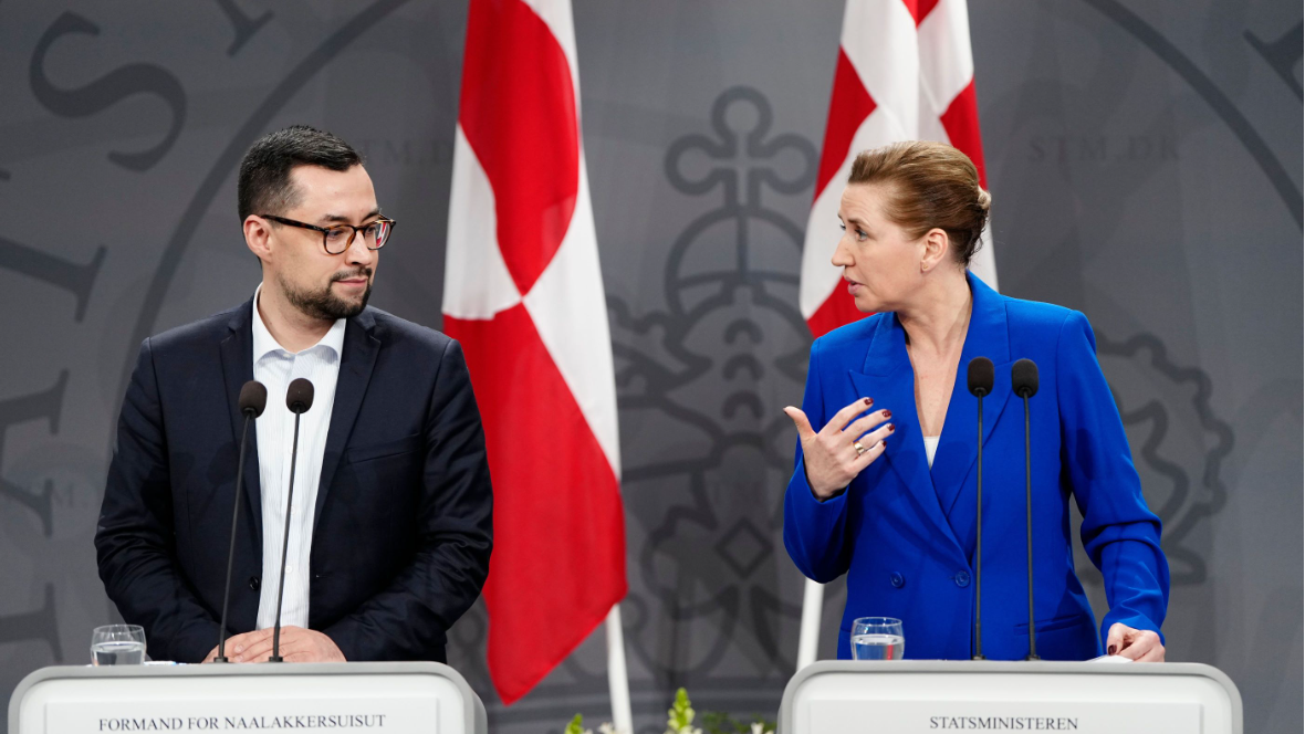 Denmark's Prime Minister Mette Frederiksen (R) and Greenland's Prime Minister Mute Bourup Egede (L) stand in front of their countries' respective flags at a joint press conference.