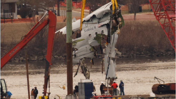 A crane lifts a piece of the American Airlines plane wreck out of the river.