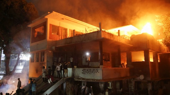 A two-storey mansion in alit and surrounded by protesters.