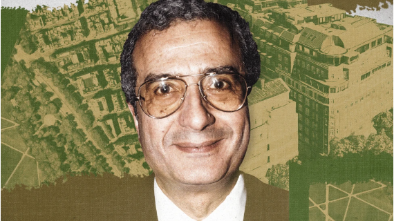 Ali Fayed has short grey curly hair and brown eyes. He is wearing aviator-style glasses, a suit and a white shirt. Behind him is an aerial view of PArk Lane near London's Hyde Park, tinged green.