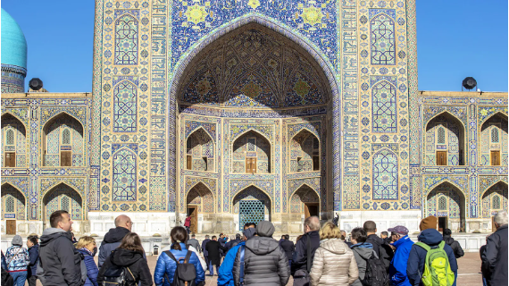 People stop outside the Hazrati Imam Complex to admire the building's mosaics 