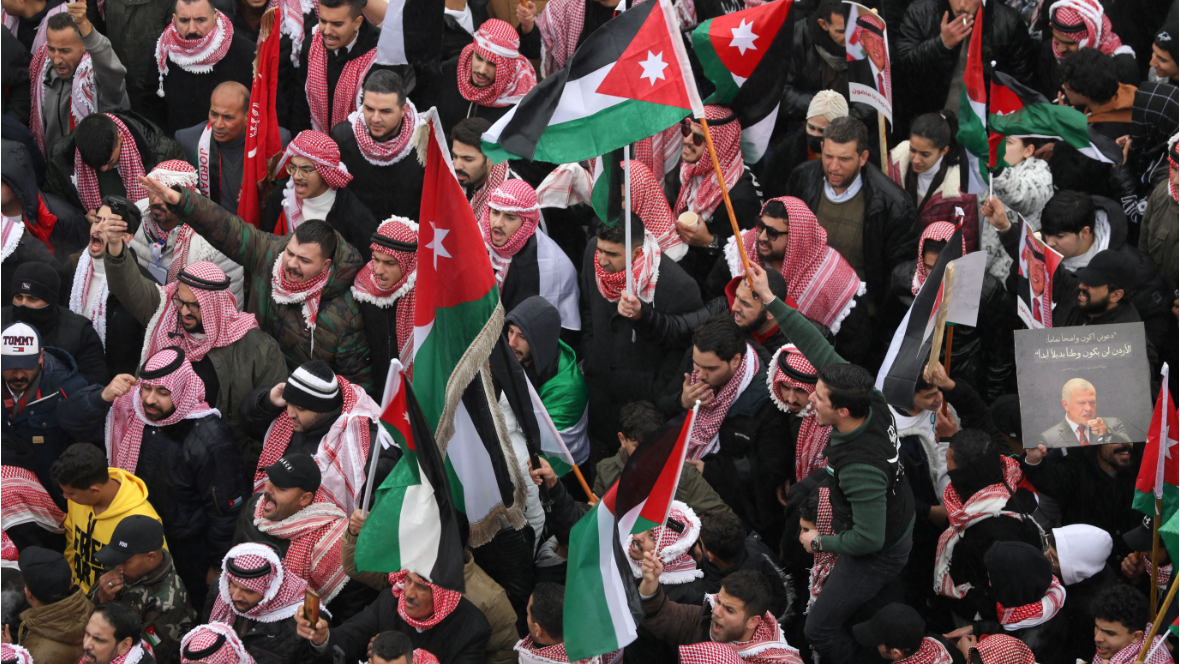 Trump faces showdown with Jordan over Gaza plan An aerial view of a demonstration in Jordan's capital Amman against Trump's plans for Gaza. Some of the demonstrators are holding Jordanian flags and pictures of the country's leader, King Abdullah. Many of the demonstrators are wearing a Jordanian shemagh, a red-and-white keffiyeh.